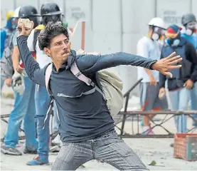  ?? AP ?? Reacción. Un manifestan­te arroja piedras contra fuerzas policiales.