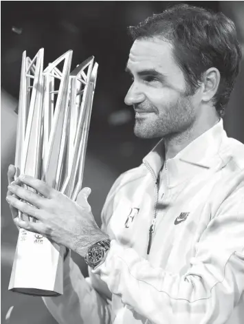  ?? AGENCE FRANCE PRESSE ?? Roger Federer of Switzerlan­d holds the trophy after winning his men's final singles match against Rafael Nadal of Spain at the Shanghai Masters tennis tournament in Shanghai.