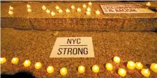  ?? (Reuters) ?? CANDLES BURN at Foley Square in New York City on Wednesday night at a vigil for victims of the pickup truck attack.