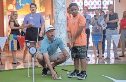  ?? BRANDON DILL/FOR THE COMMERCIAL APPEAL ?? St. Jude patient Quincy, 8, right, gets advice from profession­al golfer Chez Reavie during a round of miniature golf Tuesday on the campus of St. Jude Children's Research Hospital.