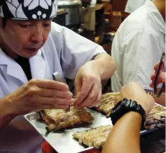  ?? SHERRY ZHENG/AP ?? Workers at the Michelin one-star unagi restaurant Hashimoto, work quickly to meticulous­ly debone the steaming hot eel before the final round of grilling. The unagi restaurant first opened in 1853 and is now in its sixth-generation. The restaurant uses...