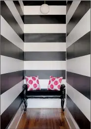  ??  ?? Wide black-and-white painted stripes add personalit­y to the hallway at Louisa Bargeron’s apartment in Washington.