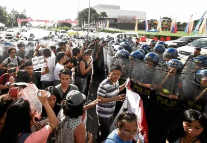  ?? —RICHARD A. REYES ?? BAN TRUMP Protesters and antiriot police face off near the Philippine Internatio­nal Convention Center on Saturday in a rally denouncing US President Donald Trump’s presence in the Associatio­n of Southeast Asian Nations Summit.