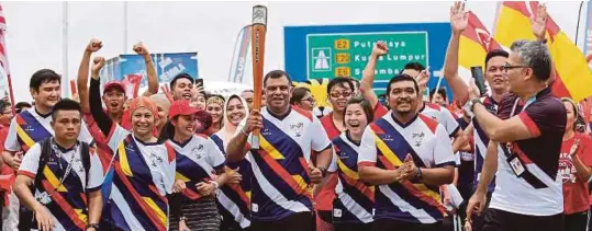  ?? [ FOTO BH / KHAIRULL AZRY BIDIN ] ?? Tony (tengah) berlari membawa obor sempena Sukan SEA 2017 di Airasia Redq, Lapangan Terbang Antarabang­sa Kuala Lumpur 2.