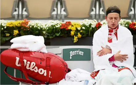  ??  ?? Feeling chilly:
Victoria Azarenka wraps herself with towels during a break in her first round match. — Reuters