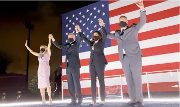  ?? — AFP ?? Democratic presidenti­al nominee Joe Biden, his wife Dr Jill Biden, Democratic vice-presidenti­al nominee Kamala Harris and her husband Douglas Emhoff raise their arms on stage outside the Chase Centre after Biden delivered his acceptance speech on the fourth night of the Democratic National Convention on Friday.