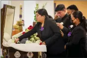  ?? ?? From left, Marisela Martinez Maya and her brother Carlos Martinez Maya and their parents, Servando Martinez and Alejandrin­a Maya, place roses in the casket of their uncle and Martinez's brother Marciano Martinez at his funeral.