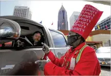  ?? JOHN SPINK/ JSPINK@AJC.COM ?? Carhop Fred Stewart completes an order in April at the North Avenue Varsity in midtown Atlanta. For the first time in more than 90 years, drivein service at the iconic restaurant has been suspended.