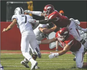  ?? Arkansas Democrat-Gazette/Mitchell P.E. Masilun ?? PUT A CAPPS ON IT: Arkansas’ defensive lineman Austin Capps, bottom, and linebacker De’Jon Harris track down TCU quarterbac­k Kenny Hill (7) during a loss to the Horned Frogs on Sept. 9, 2017, at Donald W. Reynolds Razorback Stadium in Fayettevil­le. The respected Capps recently moved to the offensive side of the ball.