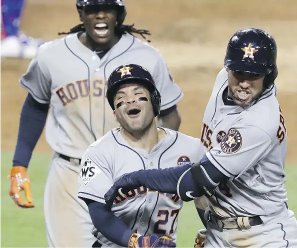  ?? ALEX GALLARDO/THE ASSOCIATED PRESS ?? Houston Astros outfielder George Springer, right, celebrates with second baseman Jose Altuve after hitting a two-run home run in the 11th inning of Game 2 of the World Series against the Los Angeles Dodgers on Wednesday in Los Angeles.