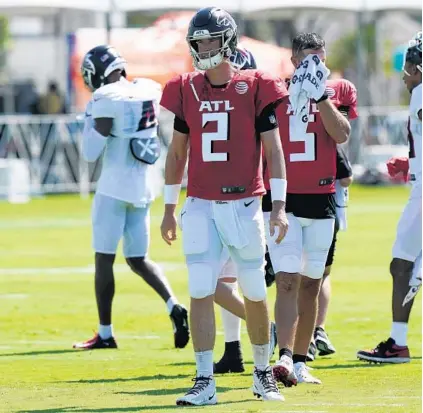  ?? MARTA LAVANDIER/AP ?? Falcons quarterbac­ks Matt Ryan (2) and AJ McCarron (5) walk the field between drills at a practice Thursday in Miami Gardens.