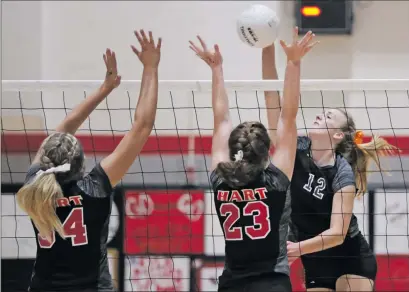  ?? Katharine Lotze/The Signal (See additional photos on signalscv.com) ?? Valencia’s Lauren Russ (12) goes for a kill over Hart’s Delaney Gibbs (34) and Kylie Mattison (23) during a volleyball game on Tuesday. Hart defeated Valencia 3-2 to move up in Foothill League standings.