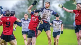  ??  ?? Adrian McIntyre of Sligo goes highest in this midfield battle against Down. Pics: Tom Callanan.