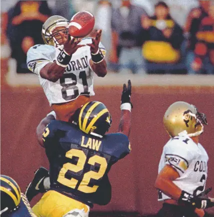  ?? Douglas Kanter, The Michigan Daily ?? Colorado’s Michael Westbrook reaches over Michigan’s Ty Law to make the game-winning catch with no time left on Sept. 24, 1994. Quarterbac­k Kordell Stewart’s 64-yard touchdown pass gave the Buffs a 27-26 victory.