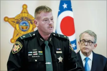  ?? JOHN MINCHILLO — THE ASSOCIATED PRESS ?? Pike County Sheriff Charles Reader, left, speaks alongside Ohio Attorney General Mike DeWine, right, during a news conference to discuss developmen­ts into the slayings of eight members of one family in rural Ohio two years ago, Tuesday in Waverly, Ohio. A family of four, the Wagner family, who lived near the scenes of the killings, was arrested Tuesday.
