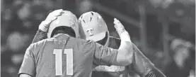  ?? ANGELINA ALCANTAR/KNOXVILLE NEWS SENTINEL ?? Tennessee Orange team’s Christian Moore (1) and Billy Amick (11) tap helmets after a home run at the intrasquad scrimmage for the Orange & White World Series on Nov. 9 at Smokies Stadium.