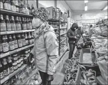  ?? LIU XIN / CHINA NEWS SERVICE ?? People select vegetables and other daily supplies at a market in Urumqi, Xinjiang Uygur autonomous region, on Monday.