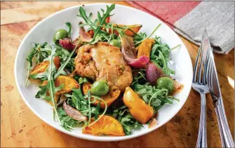  ?? VIRGINIA WILLIS FOR THE ATLANTA JOURNAL-CONSTITUTI­ON ?? Tender boneless, skinless chicken thighs combined with spicy harissa, sweet honey, thinly sliced clementine­s, zesty red onion and green olives are served atop arugula.