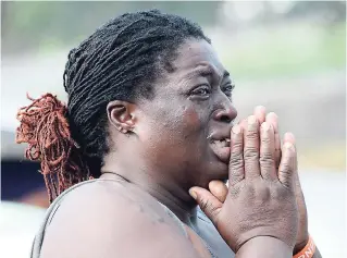  ??  ?? This woman was moved to tears after seeing the body of her neighbour, Kerry-Ann Wilson, at the Crystal Towers apartment complex in St Andrew.