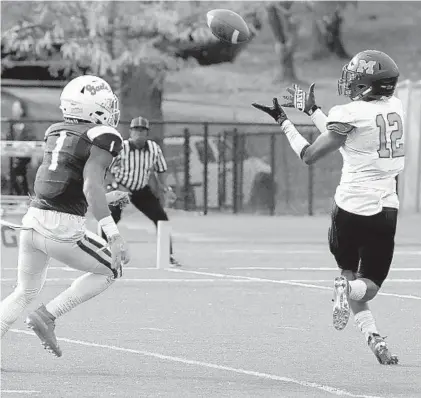  ?? KARL MERTON FERRON/BALTIMORE SUN ?? McDonogh wide receiver Dante Trader Jr. prepares to catch a pass in front of Mount Saint Joseph’s Jordan Oliver on Saturday.