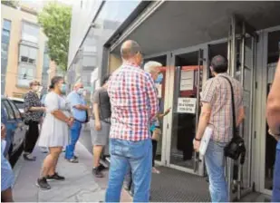  ?? G. NAVARRO ?? Varias personas esperan ante una oficina de la Seguridad Social