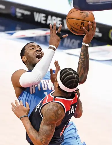  ?? Will Newton / Getty Images ?? John Wall, left, tried to bite his old team with 29 points and 11 assists, but with Bradley Beal scoring 37, the Wizards rolled.
