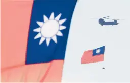  ?? CHIANG YING-YING/AP ?? A helicopter featuring Taiwan’s national flag takes part in National Day celebratio­ns Sunday in Taipei. China claims Taiwan as part of its national territory.