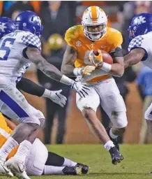  ?? PHOTO BY PATRICK MURPHY-RACEY ?? Tennessee’s Tim Jordan finds a hole against Kentucky during the fourth quarter Saturday. Jordan ran for 63 yards and a touchdown.