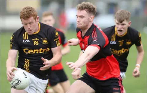  ??  ?? Ian Bradley of Adamstown under pressure from Bannow-Ballymitty’s Mark Wallace.