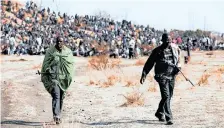  ?? DENIS FARRELL African News Agency (ANA) ?? LEADERS of striking miners walk away from a protest at the Lonmin mine near Marikana. Of the 44 people who died in the series of tragic events of August 2012, up to 37 were killed by the police. |