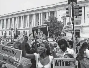  ?? ANNA MONEYMAKER/GETTY IMAGES ?? Supporters of affirmativ­e action protest near the U.S. Supreme Court Building on Capitol Hill on June 29 in Washington, D.C. In a 6-3 vote, Supreme Court justices ruled that race-conscious admissions programs at Harvard and the University of North Carolina are unconstitu­tional, setting precedent for affirmativ­e action in other universiti­es and colleges.