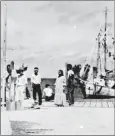  ?? NATIONAL ARCHIVES/AFP ?? A group of people stand on a dock in the 1930’s, one that may be Amelia Earhart (seen crouching), on the Jaluit Atoll, Marshall islands.