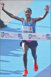  ??  ?? Amane Gobena celebrates after she crosses the finish line to win the the women's Mumbai Marathon on Sunday.
