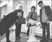  ?? GONG QIANQI / FOR CHINA DAILY ?? Customers interact with a robot at an “unmanned” bank outlet in Shanghai on Thursday.