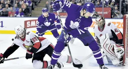  ?? .FRANK GUNN/THE CANADIAN PRESS ?? Toronto Maple Leafs’ left wing James van Riemsdyk tries to play the puck by the side of the net as Ottawa Senators’ goaltender Craig Anderson looks on while defenceman Erik Karlsson defends during second period NHL hockey action, in Toronto on Wednesday.