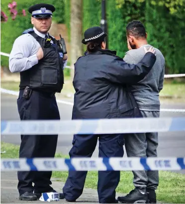  ??  ?? Ordeal: Police officers console a man after 19-year-old Abdullahi Tarabi was killed