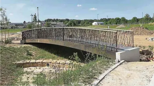  ?? Fotos: Volker Bingenheim­er ?? Die Brücke, der begrünte Wassergrab­en und drei Spielplätz­e prägen das Erscheinun­gsbild des Baugebiets.