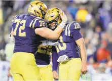  ?? ELSA/GETTY ?? Malcolm Perry (10) celebrates with Ford Higgins after scoring one of his two touchdowns during Navy’s win over Army on Saturday in Philadelph­ia. The Mids ended a threegame slide in the series.