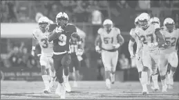  ?? PHELAN M. EBENHACK/AP ?? Central Florida running back Adrian Killins Jr. rushes for a 75-yard touchdown past UConn’s Diamond Harrell (3) and Omar Fortt (27) in the first half Saturday.