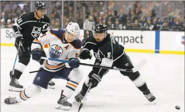  ?? Alex Gallardo Associated Press ?? THE OILERS’ RYAN NUGENT-HOPKINS, center, shoots a backhander as the Kings’ Drew Doughty defends in Sunday’s game. The Kings beat the Oilers to snap their five-game losing streak at Staples Center.