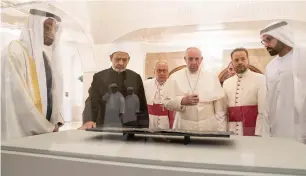  ??  ?? Sheikh Mohamed bin Zayed, Dr Ahmad El Tayyeb, Pope Francis, and Mohamed Khalifa Al Mubarak look at leaves from the Blue Quran during a reception at Al Mushrif Palace. — Wam