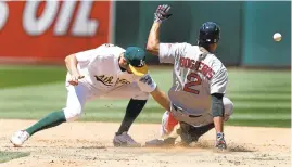  ?? ARIC CRABB/STAFF ?? Boston’s Xander Bogaerts slides safely into second base as the ball gets past A’s shortstop Adam Rosales Sunday at the Oakland Coliseum. The Red Sox prevailed 12-3.