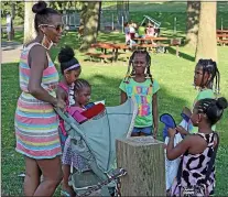  ?? CHRIS BARBER - MEDIANEWS GROUP FILE PHOTO ?? In this file photo, children inspect their new Frisbees distribute­d from the YMCA Activan during the book distributi­on in Ash Park.