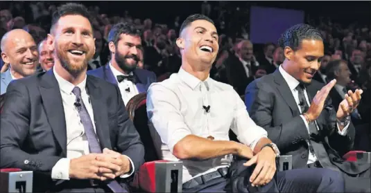  ??  ?? CRACKS. Messi y Cristiano sonríen durante un momento de la gala, mientras Van Dijk, vencedor de la noche, aplaude.