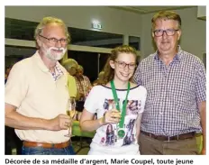  ??  ?? Décorée de sa médaille d’argent, Marie Coupel, toute jeune vice-championne du monde de bridge, pose fièrement aux côtés de son papa Harry et d’éric Arnoux, maire de Blangy.
