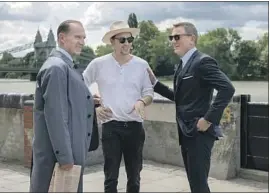  ?? Nicola Dove Danjaq LLC / MGM ?? FUKUNAGA, center, is flanked by Ralph Fiennes and Craig while filming “No Time to Die.” Fukunaga is the first American to direct a film in the franchise.