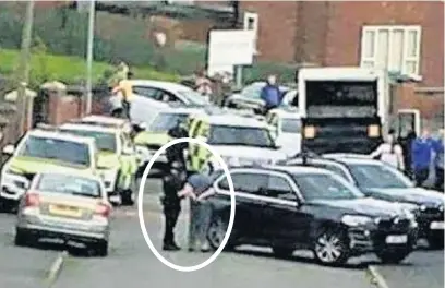  ??  ?? ●●John Burke (circled) in handcuffs after armed police raided his home