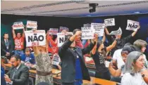  ?? ALEX FERREIRA/CâMARA DOS DEPUTADOS ?? Manifestan­tes com cartazes na comissão especial: contra o projeto