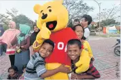  ??  ?? Indonesian children hug a Winnie the Pooh character as they attend a trauma healing programme at a shelter in Palu, Indonesia.