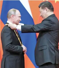  ?? Photo: Xinhua ?? Chinese President Xi Jinping (right), presidents Russian President Vladmir Putin with China’s first Friendship Medal.